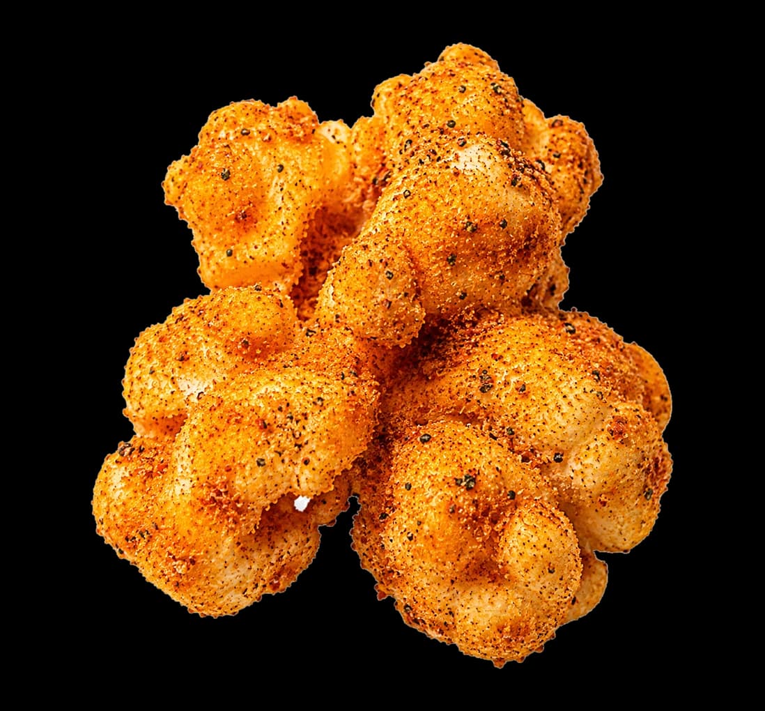 A Kernando kernel, coated on every surface in orange dry-rub seasoning and herb flecks